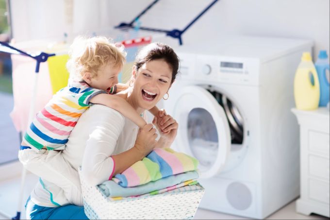 Bei Aufgaben im Haushalt geht es auch um gemeinsamen Spass und das Familiengefühl. Mama, Kind, Wäsche, Haushalt