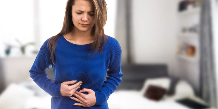 Frau Magenschmerzen Blähungen Hände Bauch