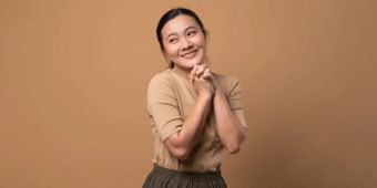 asiatische frau lächelt, brauner hintergrund