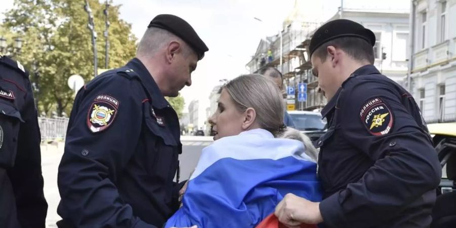 Russische Polizeibeamte verhaften eine Oppositionelle bei der nicht genehmigten Kundgebung im Zentrum der Stadt. Nach den Massenfestnahmen bei den Protesten in der russischen Hauptstadt Moskau sind mehr als 40 Demonstranten zu Arreststrafen verurteilt worden. Foto: Dmitry Serebryakov/AP