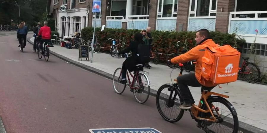 Radfahrer sind auf einer "Fietsstraat" unterwegs, einer Strasse für Radfahrer, auf der Autos nur zu Gast sind. Foto: Annette Birschel/dpa