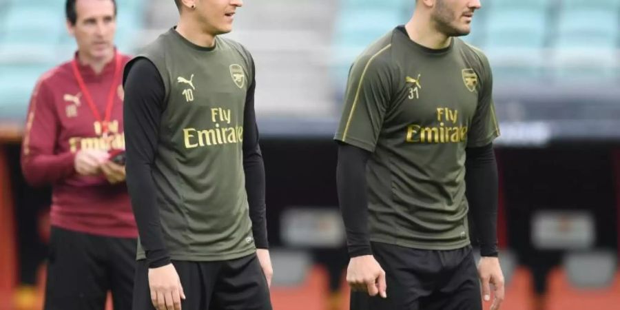 Die Zukunft von Mesut Özil (l) beim FC Arsenal ist noch fraglich. Foto: Arne Dedert