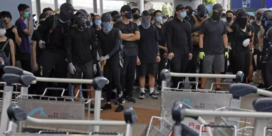 Demonstranten blockieren eine Strasse vor dem Hongkonger Flughafen. Foto: Kin Cheung/AP