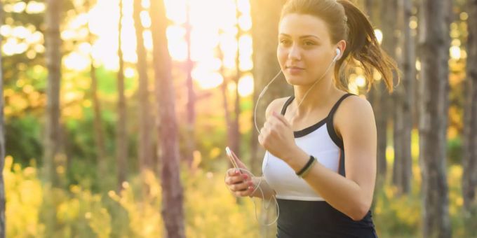 Eine Frau joggt am Morgen durch den Wald. (Symbolbild) Körperliche Aktivität Zyklussynchronisation