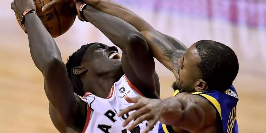 Pascal Siakam (l) von den Toronto Raptors im verteidigt den Ballbesitz gegen Andre Iguodala von den Golden State Warriors. Foto: Frank Gunn/The Canadian Press/AP