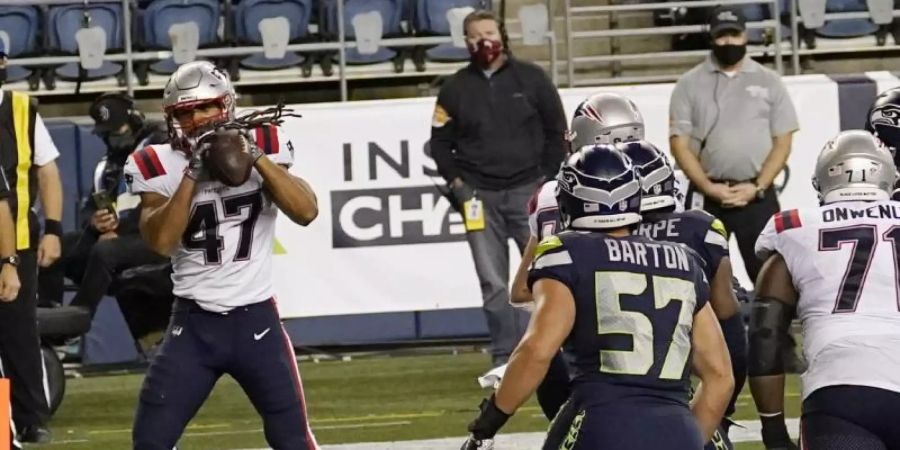 Jakob Johnson (l) von den New England Patriots fängt einen Touchdown. Foto: Elaine Thompson/AP/dpa