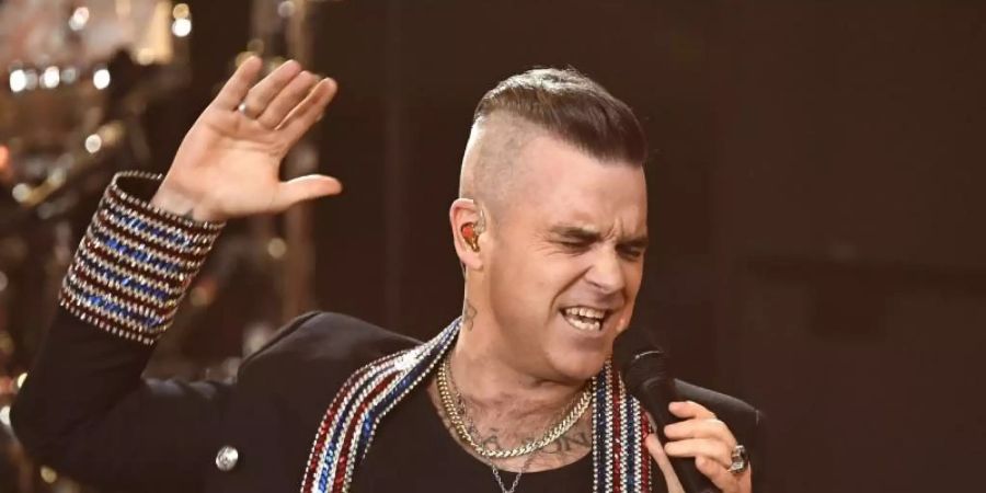 Robbie Williams lockert mit etwas Humor die Krisen-Stimmung auf. Foto: Jens Meyer/AP/Pool/dpa