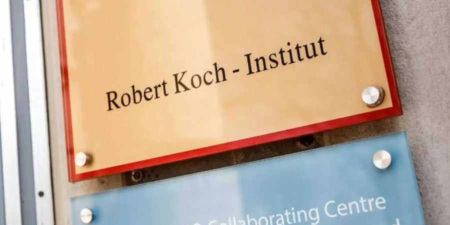 Ein Schild mit der Aufschrift "Robert Koch-Institut" weist auf den Eingang des Gebäudes hin. Foto: Carsten Koall/dpa