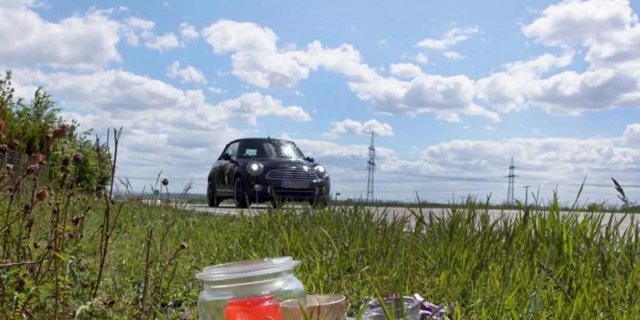 Kerzen und Blumen sind an der Unfallstelle an einer Landstrasse bei Sachsenheim aufgestellt. Dort war der Angeklagte nach in eine Gruppe von vier Fussgängern gefahren. Foto: Andreas Rosar/dpa