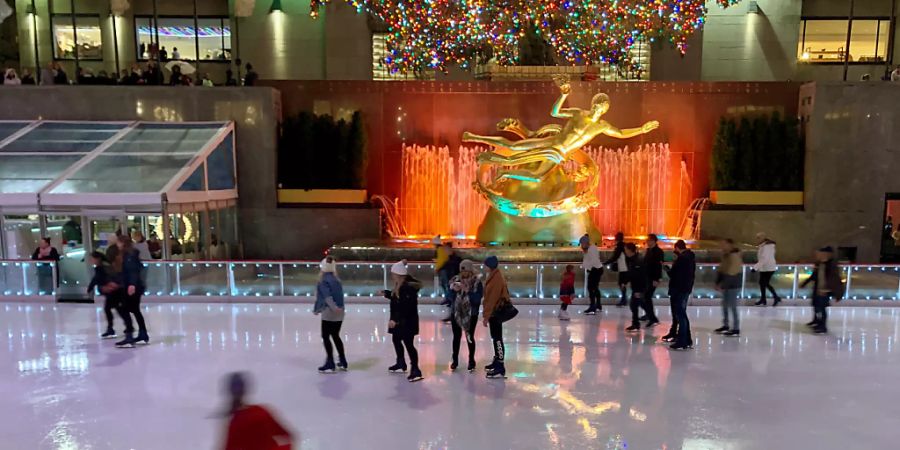 ARCHIV - Auf der Eisfläche der Schlittschuhbahn am Rockefeller Center spiegeln sich die bunten Lichter des wohl berühmtesten Weihnachtsbaums der Welt. Foto: Benno Schwinghammer/dpa