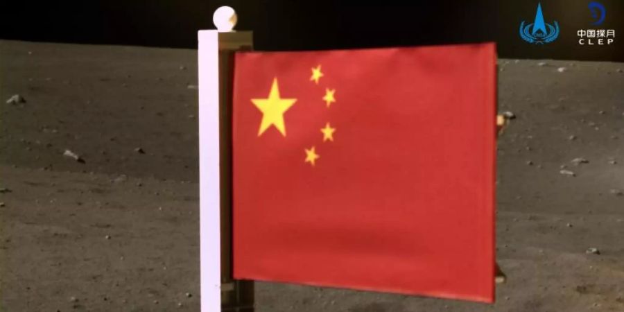 Das von der Nationalen Raumfahrtbehörde Chinas (CNSA) veröffentlichte Bild zeigt Chinas Nationalflagge, die von der Sonde «Chang'e 5» auf dem Mond entfaltet wurde. Das Bild wurde vor Beginn der Rückkehr mit Mondproben von einer Panoramakamera an Bord des Landegeräts der Sonde aufgenommen. Foto: CNSA/XinHua/dpa