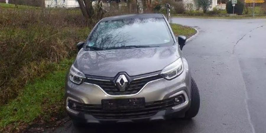 Ein Auto der Marke Renault mit der Leiche einer 48-jährigen Frau im Kofferraum steht ohne Kennzeichen abgestellt am Fahrbahnrand. Foto: Polizei Bonn/dpa