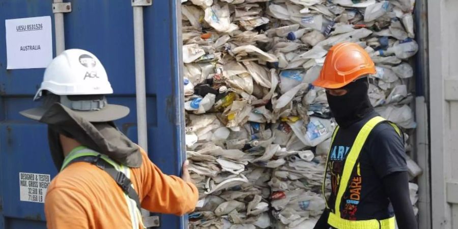 Arbeiter öffnen in Malaysia einen Container voller nicht recycelbarer Kunststoffe. 2020 wurden 151.000 Tonnen Plastikmüll nach Malaysia verschifft. Foto: Vincent Thian/AP/dpa