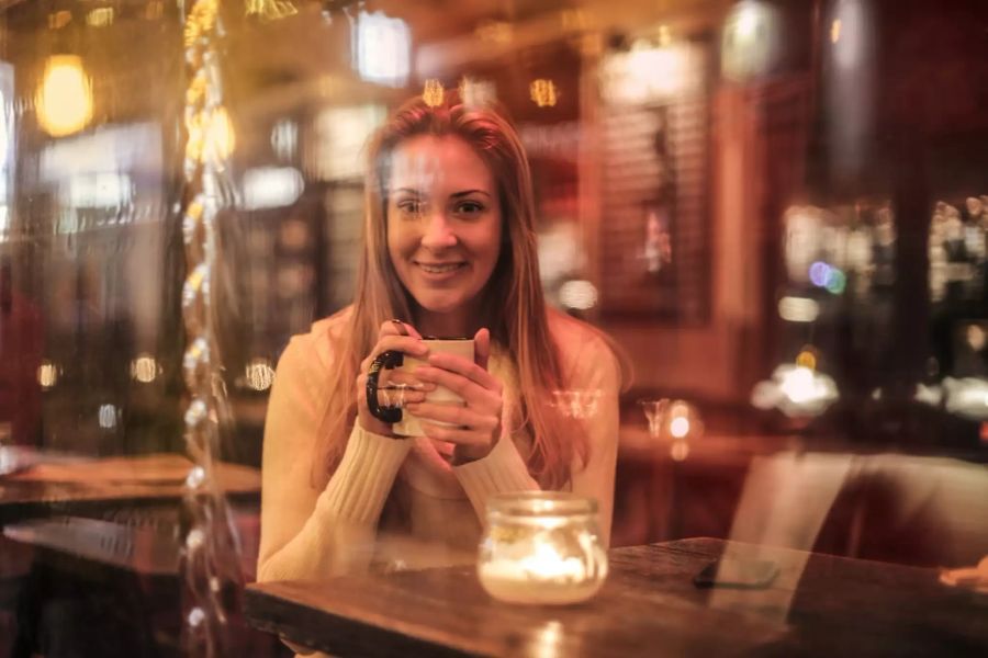 Frau trinkt Bier in Bar