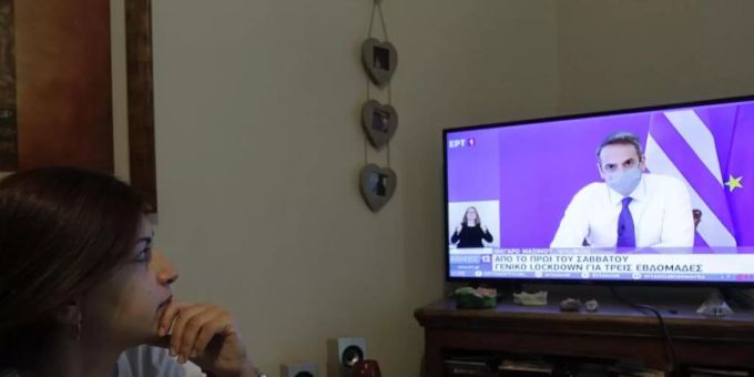 Eine Frau verfolgt die TV-Ansprache von Griechenlands Premierminister Mitsotakis. Foto: Aristidis Vafeiadakis/ZUMA Wire/dpa Eine Frau verfolgt die TV-Ansprache von Griechenlands Premierminister Mitsotakis. Foto: Aristidis Vafeiadakis/ZUMA Wire/dpa
