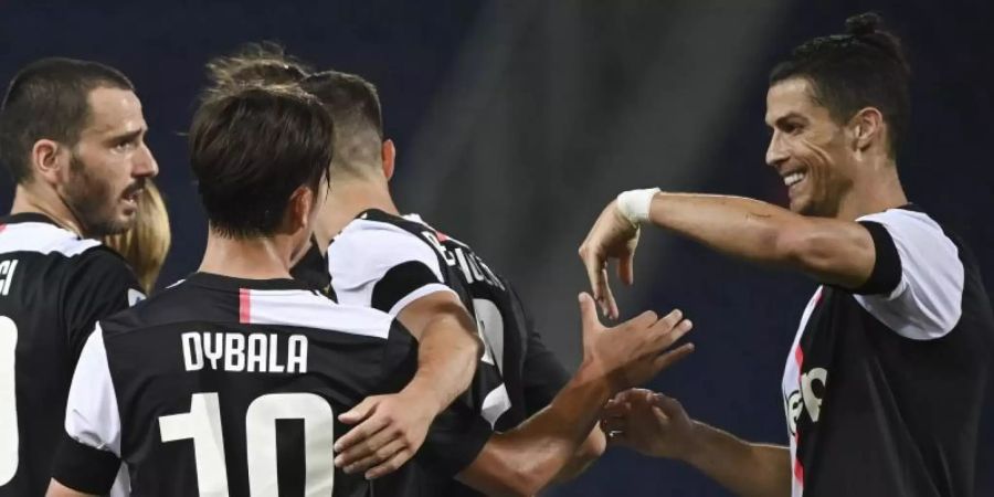 Cristiano Ronaldo (r) gratuliert Paulo Dybala (2.v.l) zu seinem Treffer zum 2:0 für Juve gegen den FC Bologna. Foto: Massimo Paolone/LaPresse/AP/dpa