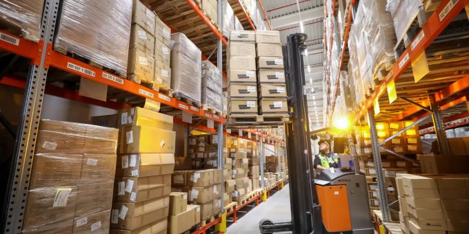 Ein Mitarbeiter des Logistikunternehmens Kühne & Nagel stapelt im Wareneingang Kartons. Kühne + nagel