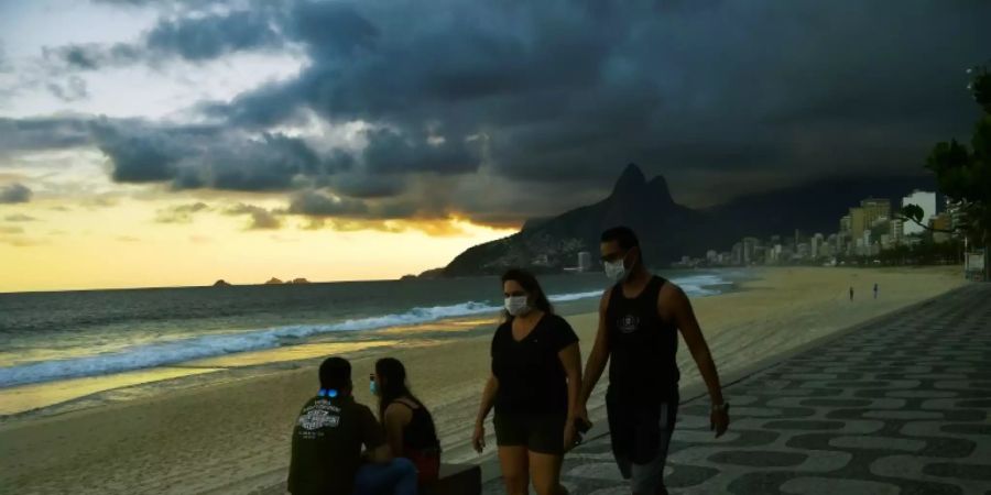 Menschen mit Schutzmasken am Ipanema-Strand in Rio de Janeiro