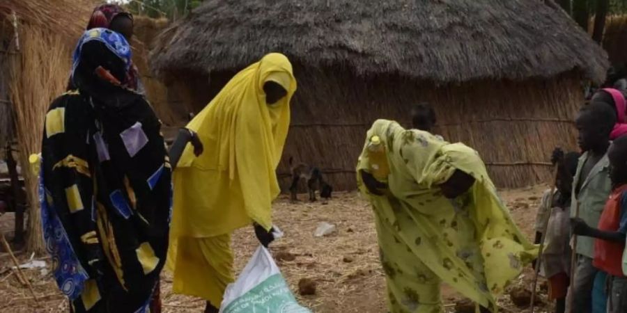 Drei Frauen nehmen im Sudan Spenden einer humanitären Organisation entgegen. Bei einer Online-Geberkonferenz kamen rund 1,8 Milliarden Dollar für den Reformprozess im Sudan zusammen. Foto: -/Saudi Press Agency/dpa