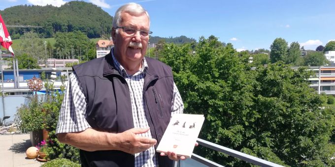 Bruno Maurer auf seinem Balkon in Bolligen. In seiner Hand hält er sein neustes Werk «Ds Läbe i üsere Gmeind». Bruno Maurer Bolligen