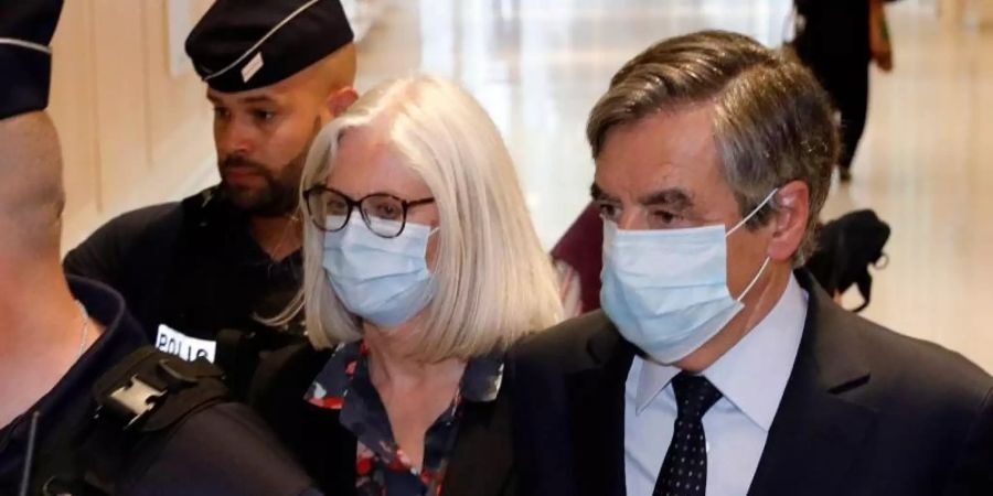 Francois Fillon (r), ehemaliger Premierminister von Frankreich, und seine Frau Penelope Fillon (2.v.r) beim Verlassen des Gerichtsgebäudes. Foto: Thomas Samson/AFP/dpa