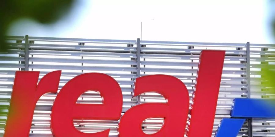 Das Logo der Real SB-Warenhauskette steht an einer Filiale. Foto: Martin Gerten/dpa