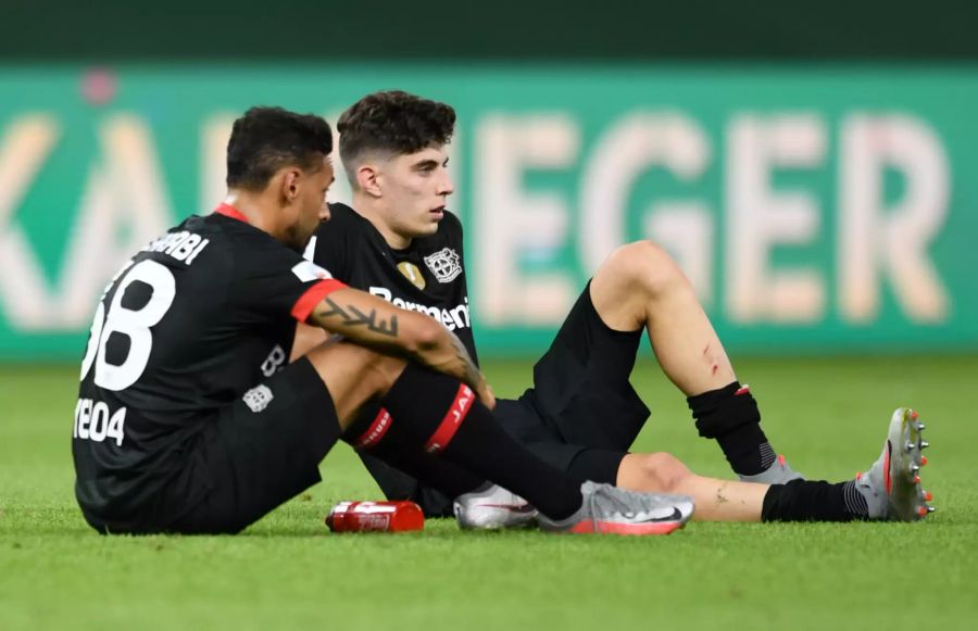 Leverkusens Kai Havertz (r.) und Karim Bellarabi sitzen nach dem verlorenen DFB-Pokalfinale enttäuscht auf dem Rasen.