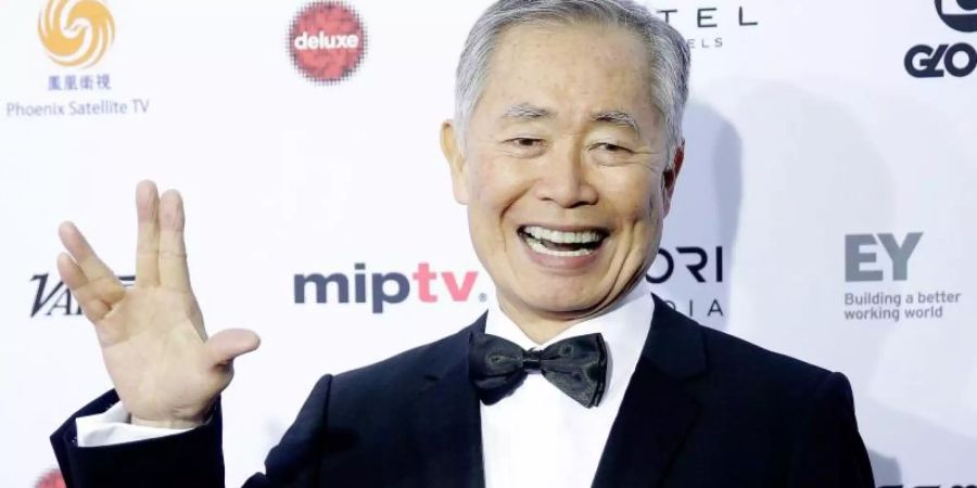 US-Schauspieler George Takei trifft 2015 zur Verleihung der International Emmy Awards ein und grüsst mit dem Vulkanier-Gruss. Foto: Andrew Gombert/EPA/dpa