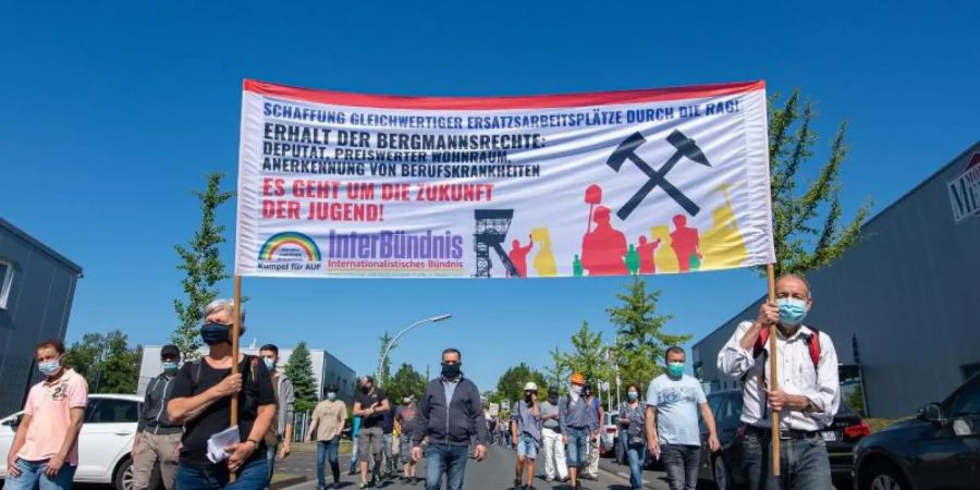 Ehemalige Bergleute gehen zum Kohlekraftwerk in Datteln und demonstrieren gegen die Inbetriebnahme. Foto: Guido Kirchner/dpa