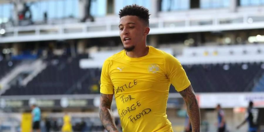 Dortmunds Jadon Sancho zeigt beim ersten seiner drei Tore gegen Paderborn ein Shirt mit dem Schriftzug «Justice for George Floyd». Foto: Lars Baron/Getty Images Europe/Pool/dpa