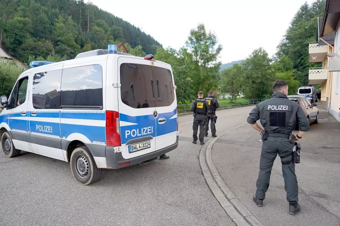 Polizisten stehen heute Freitag bei Oppenau vor einer Einfahrt in ein Waldgebiet. Oppenau