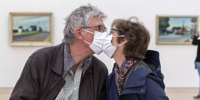 Museums-Besucher mit Gesichtsmasken küssen sich. (Symbolbild) coronavirus