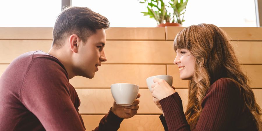 Ein Paar, das gemeinsam Kaffee trinkt und diskutiert.