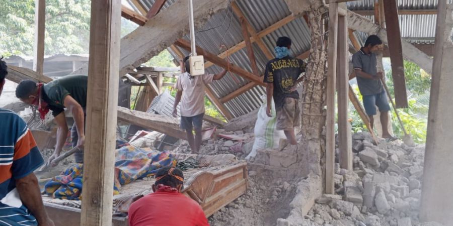 Menschen räumen die Trümmer eines durch ein Erdbeben beschädigten Hauses in Ost-Manggarai in der Provinz Ost-Nusa Tenggara weg. Foto: Kurniawan/AP/dpa