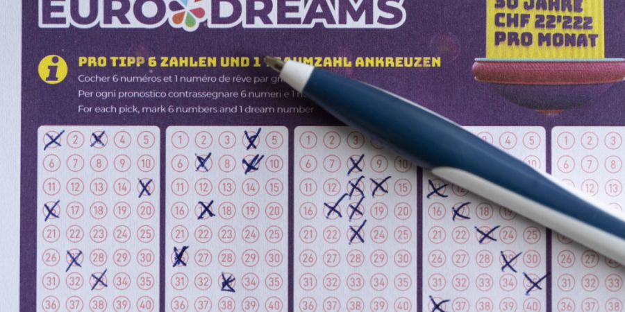 Eine Person füllt einen Euro-Dreams Spielschein von Swisslos aus. (Archivbild)