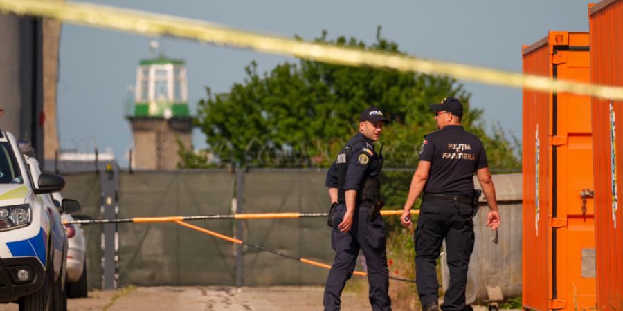 Rumänische Grenzpolizisten sichern einen Eingang in der Nähe eines beschädigten Lagerhauses nach der Explosion einer Drohne im Schwarzmeerhafen von Constanta. Foto: Vadim Ghirda/AP/dpa