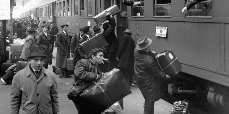 Sogenannte Saisonniers mussten nach Ablauf des Arbeitsvertrags die Schweiz wieder verlassen. Im Bild zu sehen sind italienische Gastarbeiter im Jahre 1964 in Zürich, die für die Festt...