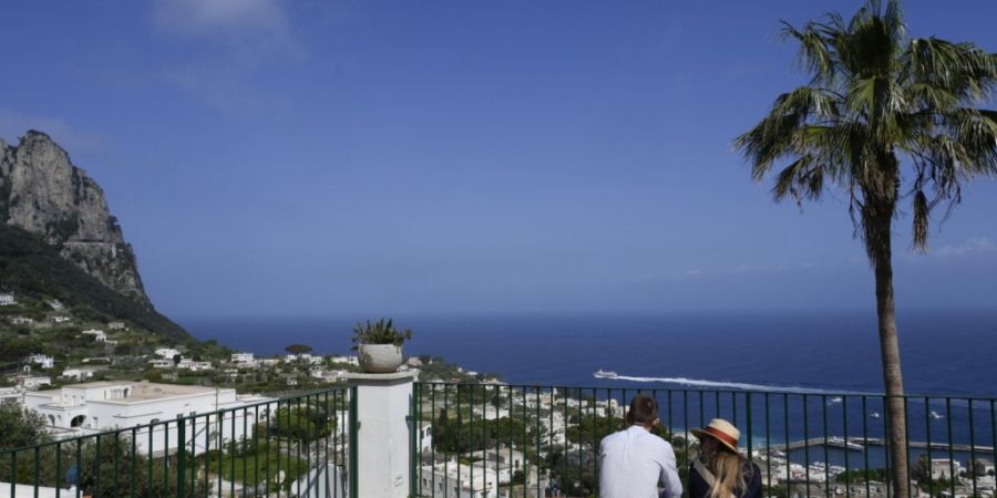 ARCHIV - Touristen blicken auf die Häuser von Capri. Foto: Gregorio Borgia/AP/dpa