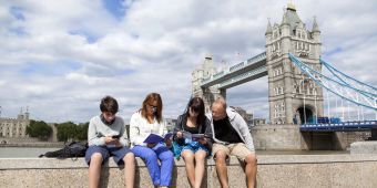 Familie auf einer Mauer vor der tower-Bridge in London.