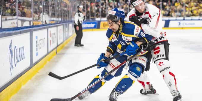 Andres Ambühl wird von Kanadas Daniel Carr bedrängt. HC Davos Spengler Cup