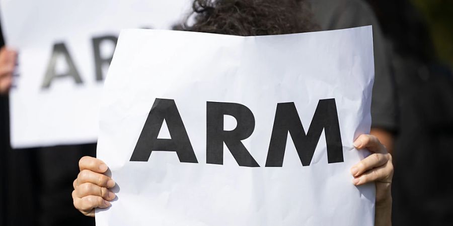 ARCHIV - Eine Teilnehmerin einer Fotoaktion der Landesarmutskonferenz im Jahr 2022 zu Beginn der landesweiten Aktionswoche «Armut bedroht alle» hält ein Papier, auf dem das Wort «Arm» zu sehen ist in den Händen. Foto: Marijan Murat/dpa