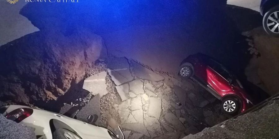 Die zwei geparkten Autos liegen in dem Erdloch.