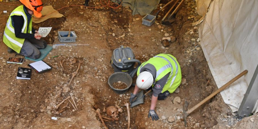 Archäologinnen haben die Skelette von zwei Personen freigelegt, deren Köpfe zwischen den Beinen liegen.