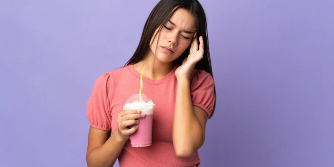 Frau mit Shake hat Kopfschmerzen