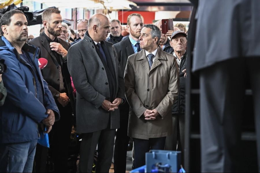 Alain Berset und Ignazio Cassis treffen sich nach der Sitzung "extra muros" mit der Bevölkerung im Verkehrshaus Luzern. Sie werden flankiert von zwei Personenschützern.
