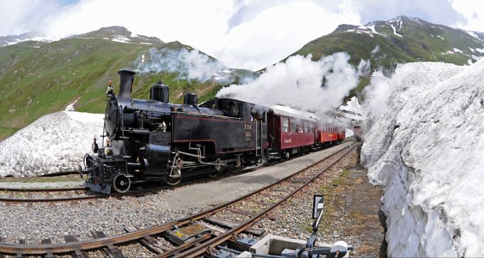 Hier kommt der Zug aus dem Scheiteltunnel Dampflok Zug Berge Schnee