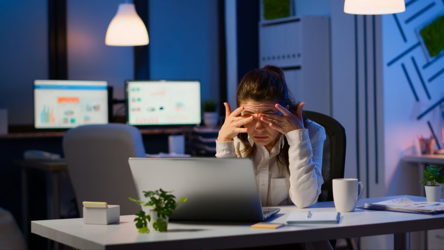 Erschöpfte Frau macht Überstunden im Büro