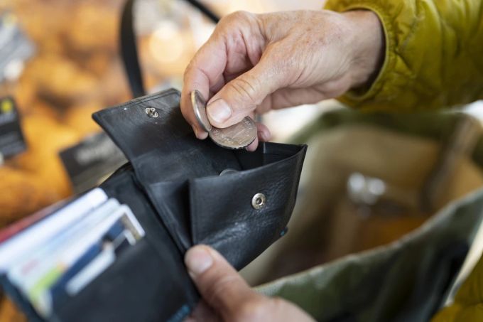 Eine Person zieht während dem Markt auf dem Helvetiaplatz in Zürich Münzen aus ihrem Portemonnaie. Portemonnaie Münzen Kaufkraft