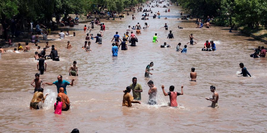 Menschen kühlen sich in Lahore bei heissem Wetter in einem Kanal ab.