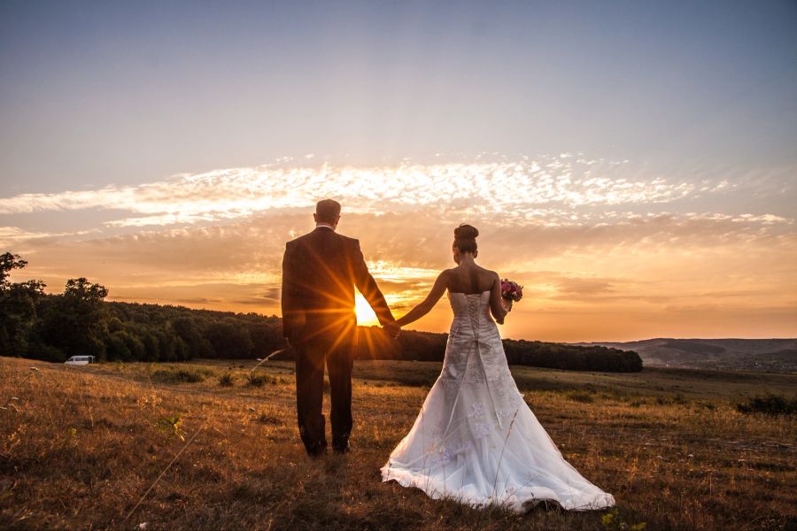 Hochzeitspaar auf dem Feld im Sonnenuntergang